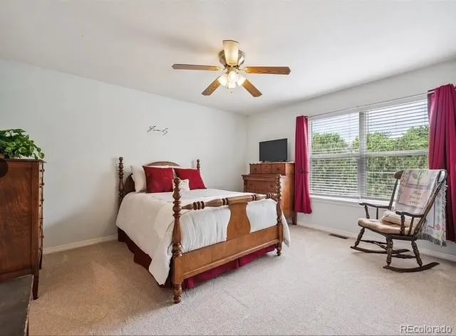 a bedroom with bed couch and window