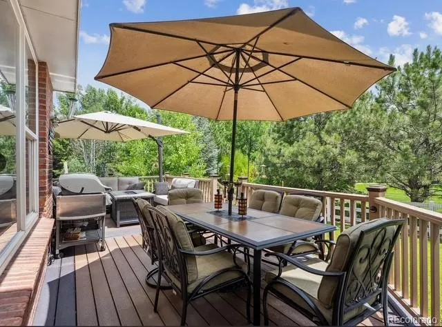 a view of a patio with wooden floor table and chairs
