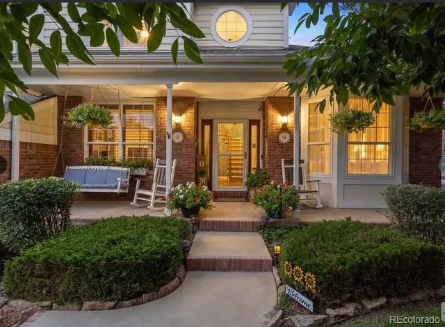 a view of a house with potted plants and a large tree