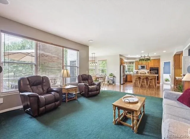 a dining room with furniture a chandelier and wooden floor