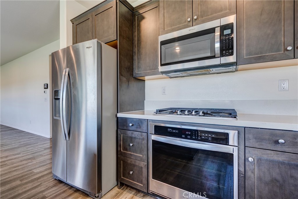 28295 Memory Lane Winchester, CA 92596 - Photo 23 of 68 a kitchen with stainless steel appliances wooden cabinets and a stove top oven