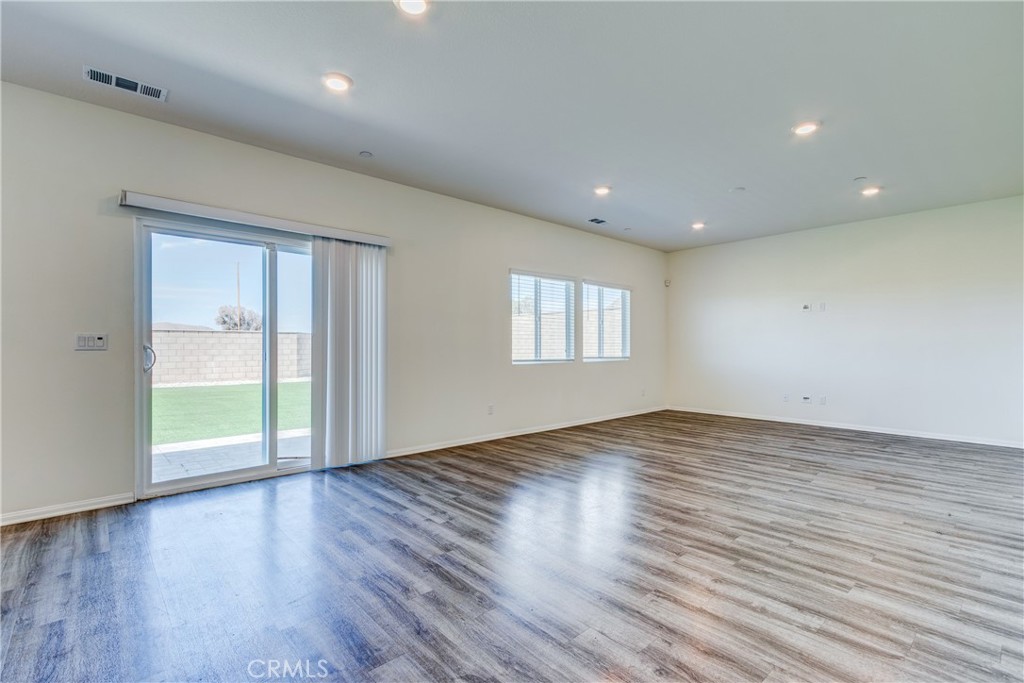 28295 Memory Lane Winchester, CA 92596 - Photo 3 of 68 a view of an empty room with wooden floor and a window