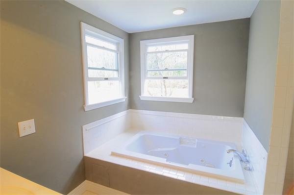 96 Adams Road Grafton, MA 01536 - Photo 17 of 24 a bath tub sitting in a bathroom next to a window