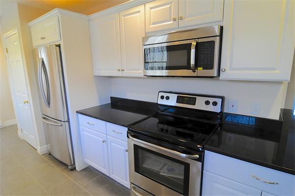 96 Adams Road Grafton, MA 01536 - Photo 2 of 24 a kitchen with stainless steel appliances a stove a microwave and a refrigerator