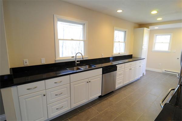 96 Adams Road Grafton, MA 01536 - Photo 5 of 24 a kitchen with granite countertop white cabinets sink and window