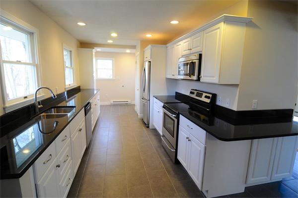 96 Adams Road Grafton, MA 01536 - Photo 6 of 24 a kitchen with granite countertop a sink a counter top space stainless steel appliances a window and a counter top space