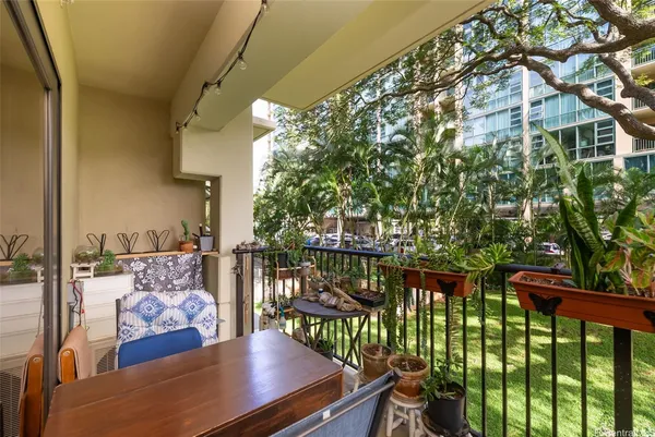 a view of a balcony with chairs and a potted plant