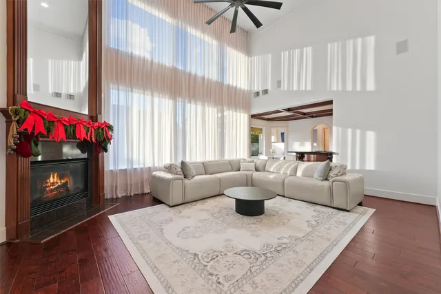 a kitchen with stainless steel appliances granite countertop a stove a refrigerator a sink and white cabinets with wooden floor