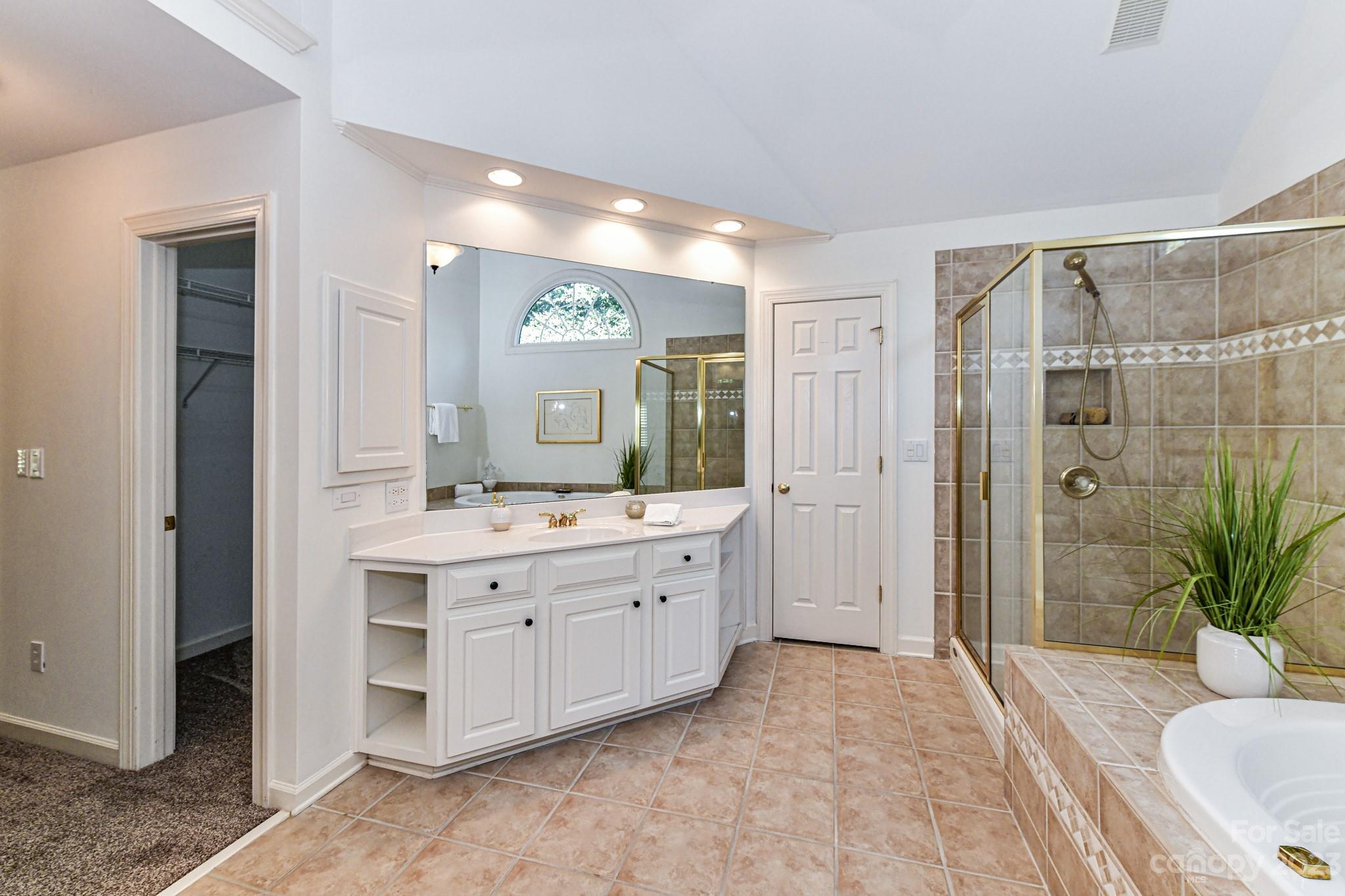 4030 Fawn Hill Road Matthews, NC 28105 - Photo 24 of 48 a spacious bathroom with a granite countertop sink mirror and shower