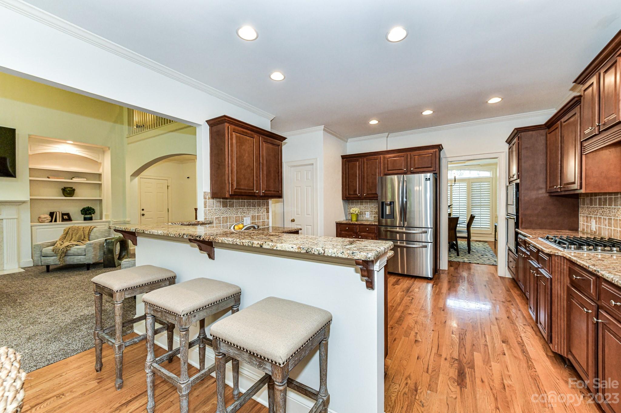 4030 Fawn Hill Road Matthews, NC 28105 - Photo 8 of 48 a large kitchen with stainless steel appliances lots of counter top space and a wooden floor