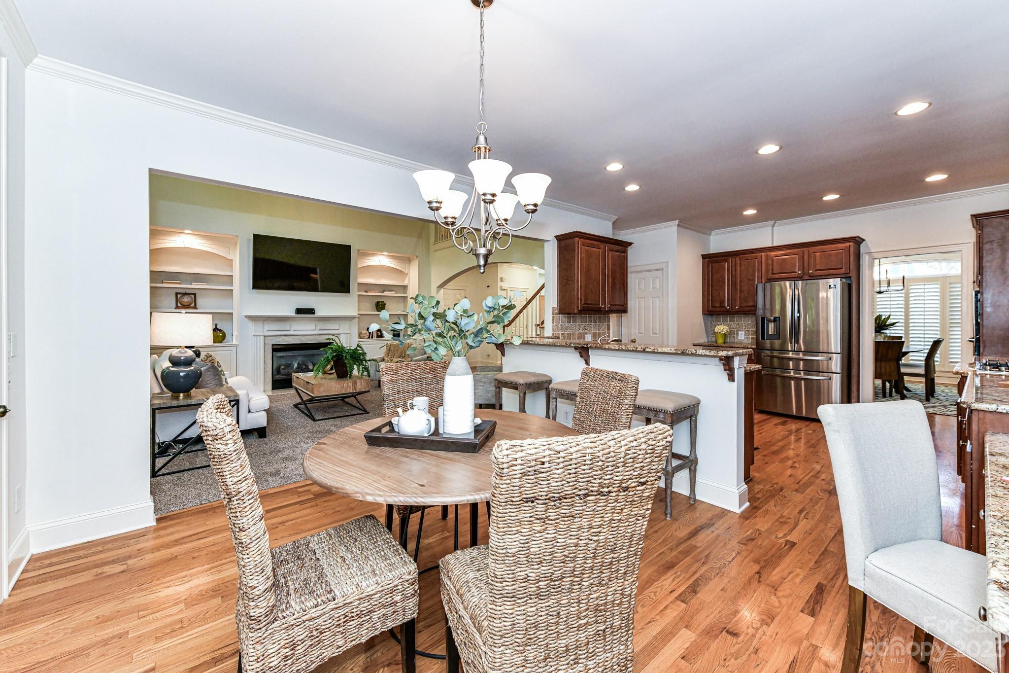 4030 Fawn Hill Road Matthews, NC 28105 - Photo 10 of 48 a dining room with furniture a kitchen a chandelier and wooden floor