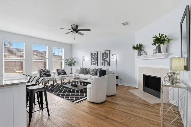 a living room with furniture a fireplace and a floor to ceiling window
