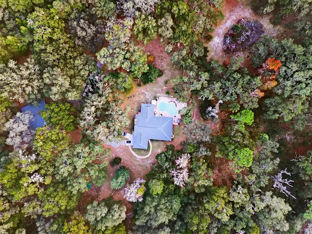 an aerial view of a house with a yard and garden