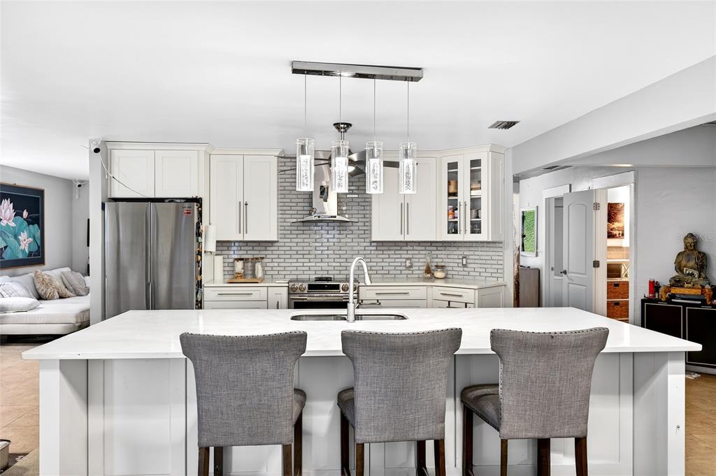 11795 Southwest Highway 484 Dunnellon, FL 34432 - Photo 18 of 51 a kitchen with stainless steel appliances kitchen island granite countertop a dining table chairs and a refrigerator
