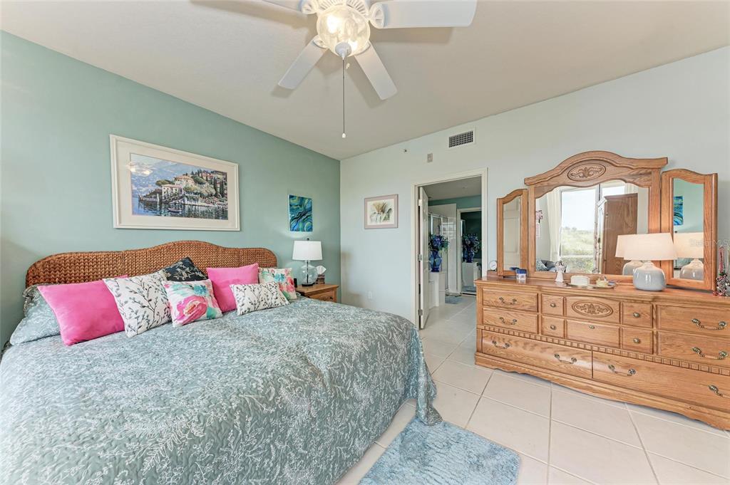 23261 Banbury Way, Unit 501 Venice, FL 34293 - Photo 16 of 75 a spacious bedroom with a large bed and a chandelier