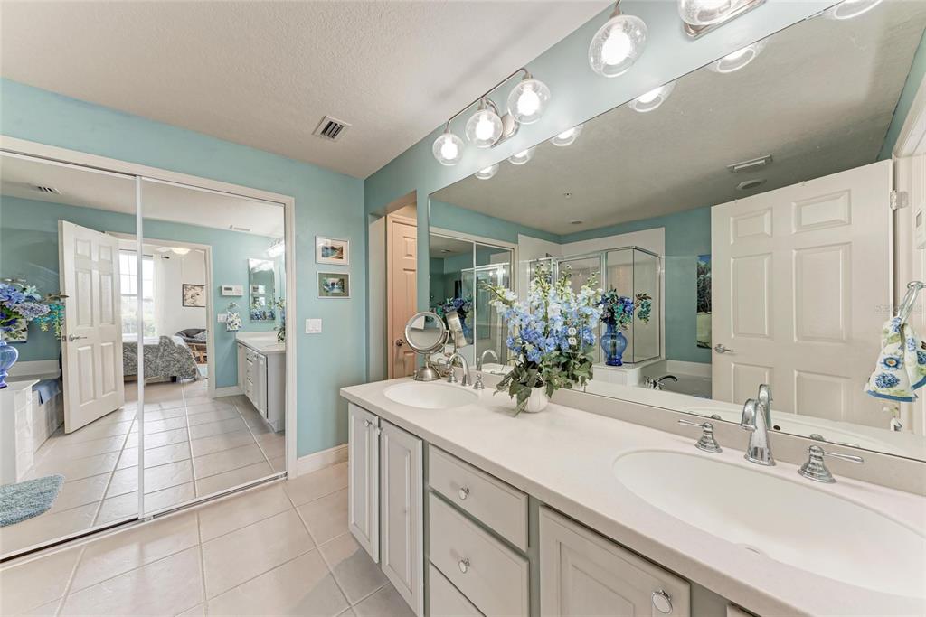 23261 Banbury Way, Unit 501 Venice, FL 34293 - Photo 20 of 75 a spacious bathroom with a double vanity sink a mirror and a shower