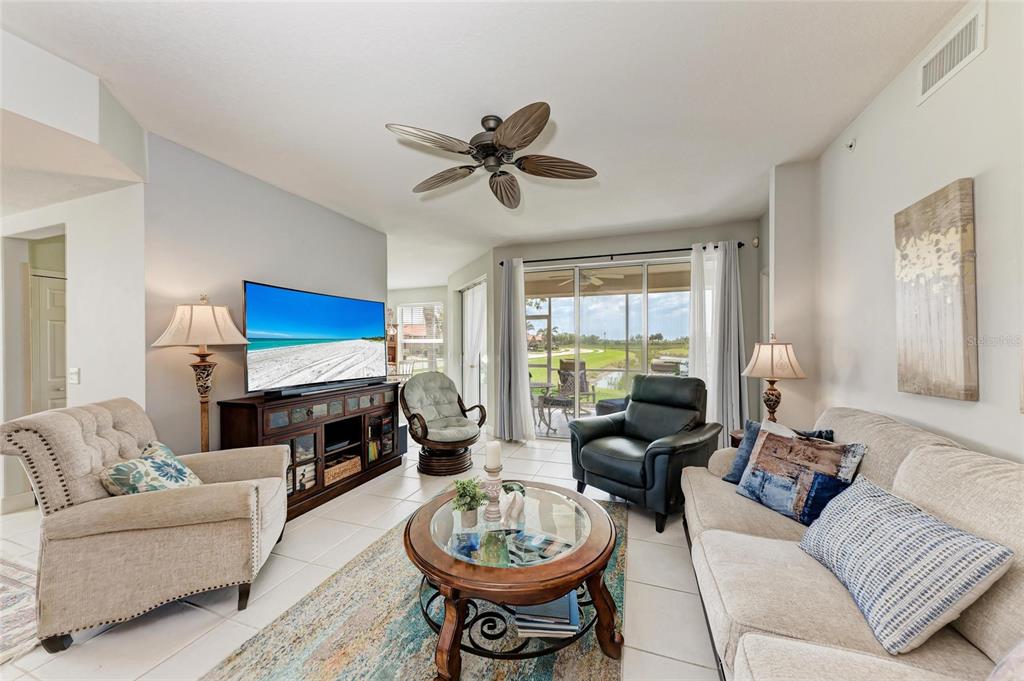 23261 Banbury Way, Unit 501 Venice, FL 34293 - Photo 4 of 75 a living room with furniture a fireplace and a window