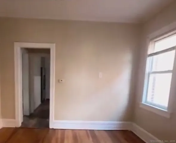 a view of a small space with wooden floor and a window