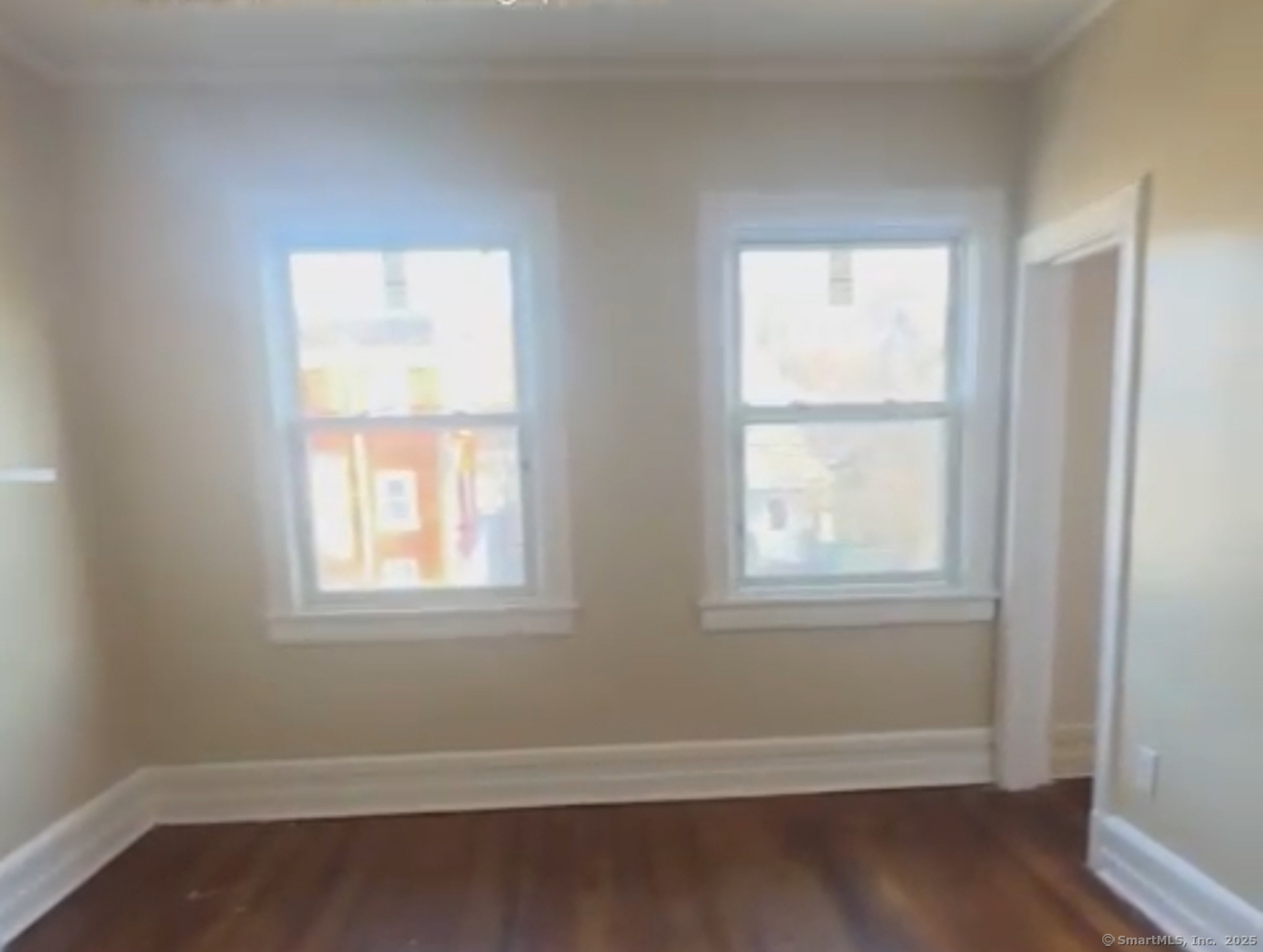 289 Dover Street, Unit 2L Bridgeport, CT 06610 - Photo 2 of 2 an empty room with wooden floor and windows