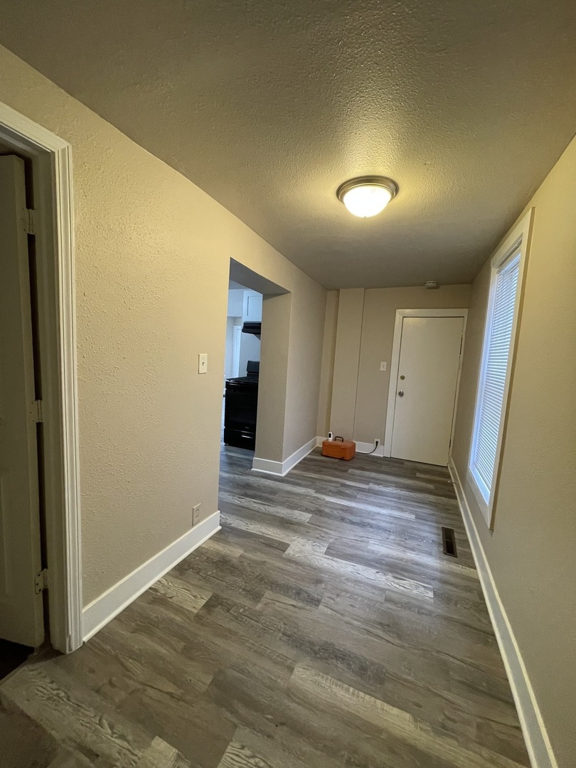 11634 South Princeton Avenue Chicago, IL 60628 - Photo 13 of 18 a view of hallway with wooden floor