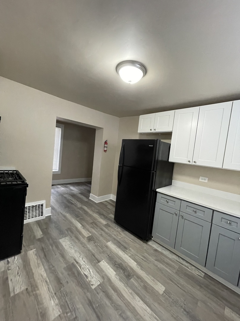 11634 South Princeton Avenue Chicago, IL 60628 - Photo 3 of 18 a kitchen with a refrigerator and cabinets