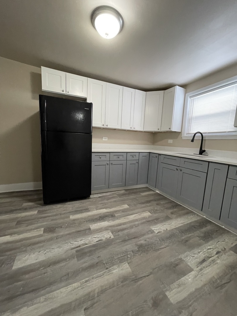 11634 South Princeton Avenue Chicago, IL 60628 - Photo 4 of 18 a kitchen with a sink and cabinets