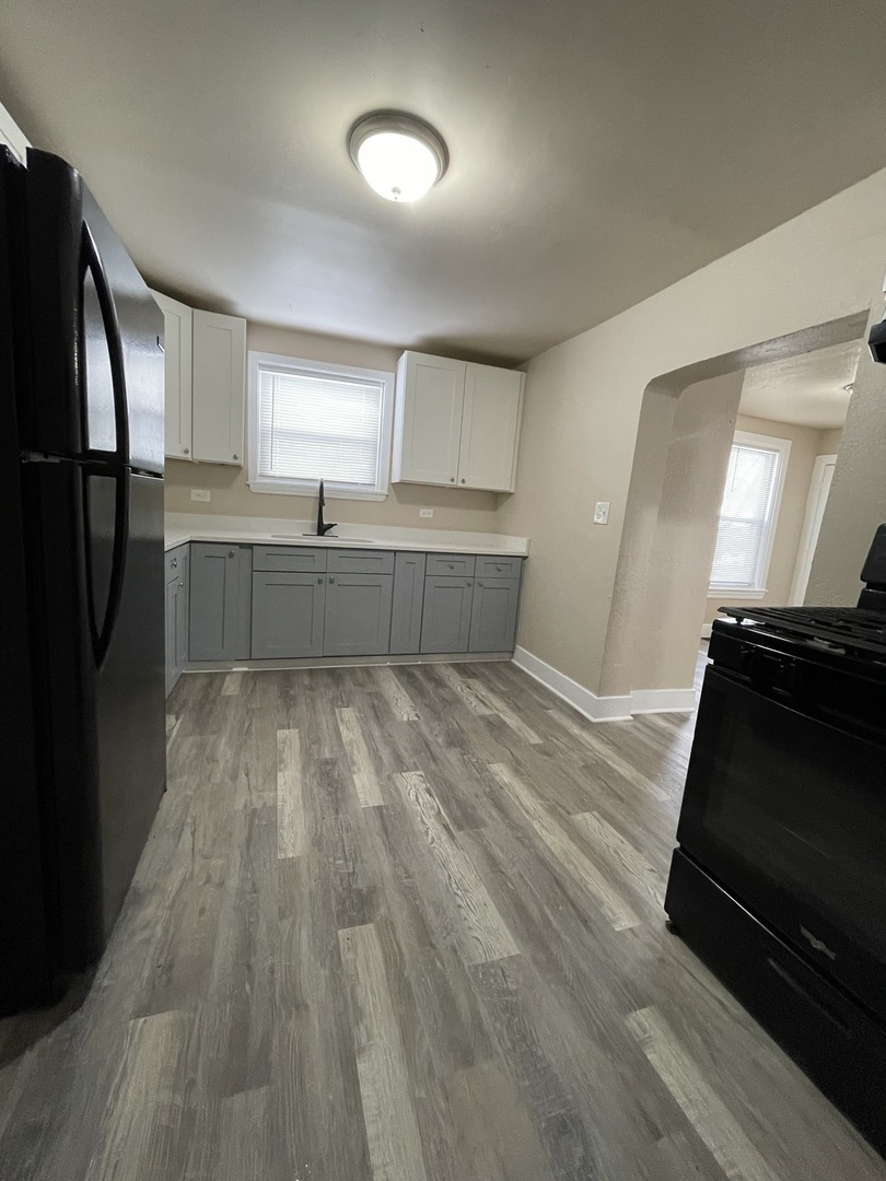 11634 South Princeton Avenue Chicago, IL 60628 - Photo 5 of 18 a room with a refrigerator and a window