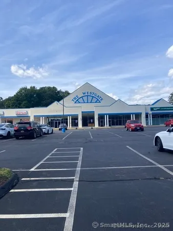 a view of building with cars parked across