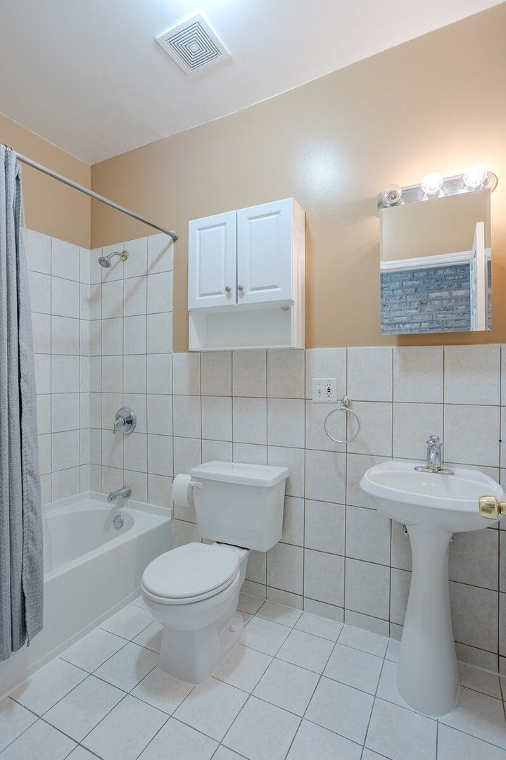 3100 West Addison Street, Unit 1A Chicago, IL 60618 - Photo 18 of 29 a bathroom with a sink a toilet and shower