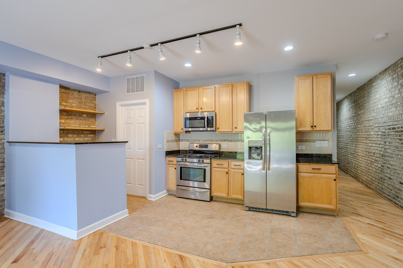 3100 West Addison Street, Unit 1A Chicago, IL 60618 - Photo 8 of 29 a kitchen with stainless steel appliances granite countertop a refrigerator a stove and a sink