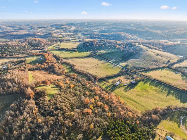 an aerial view of residential houses with outdoor space and lake view