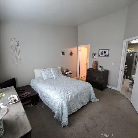 a bed room with a bed and a flat tv screen on a dresser