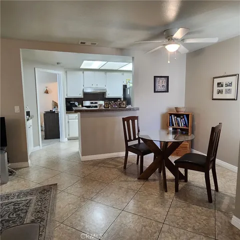 a kitchen with a dining table chairs and a refrigerator