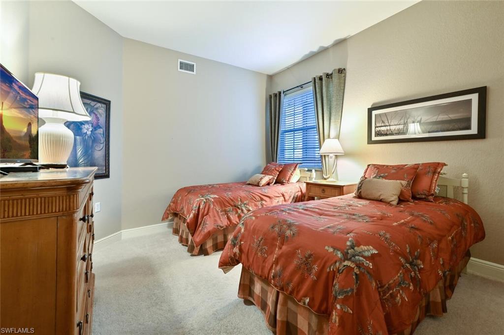793 Regency Reserve Circle, Unit 4502 Naples, FL 34119 - Photo 16 of 24 a bedroom with two beds and a flat screen tv