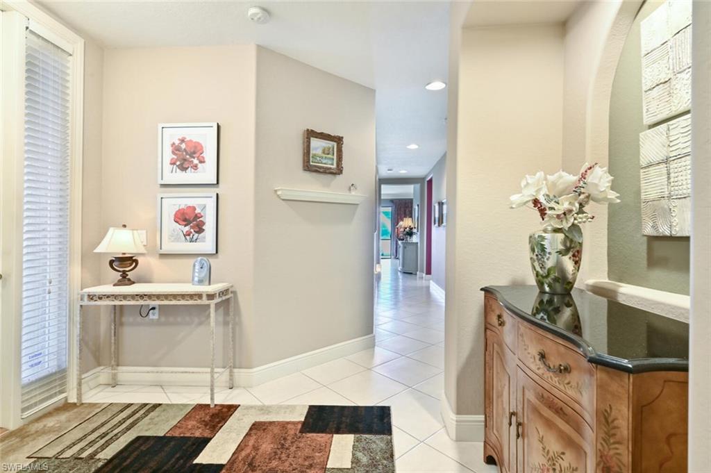 793 Regency Reserve Circle, Unit 4502 Naples, FL 34119 - Photo 4 of 24 a living room with stainless steel appliances furniture a rug and a window
