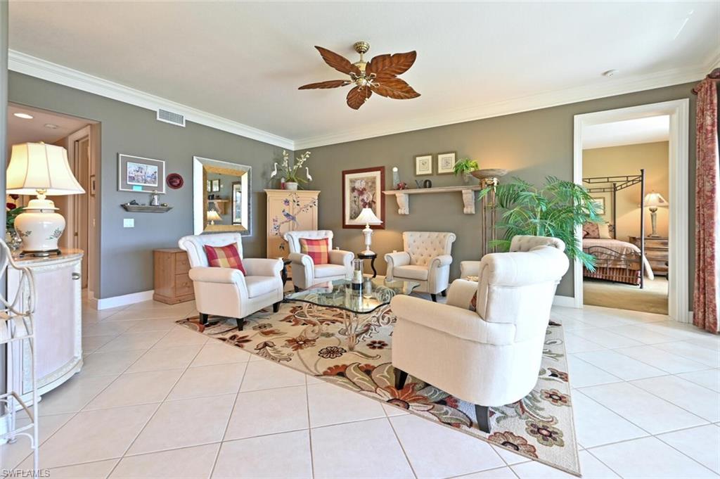 793 Regency Reserve Circle, Unit 4502 Naples, FL 34119 - Photo 7 of 24 a living room with furniture a chandelier and a glass top table