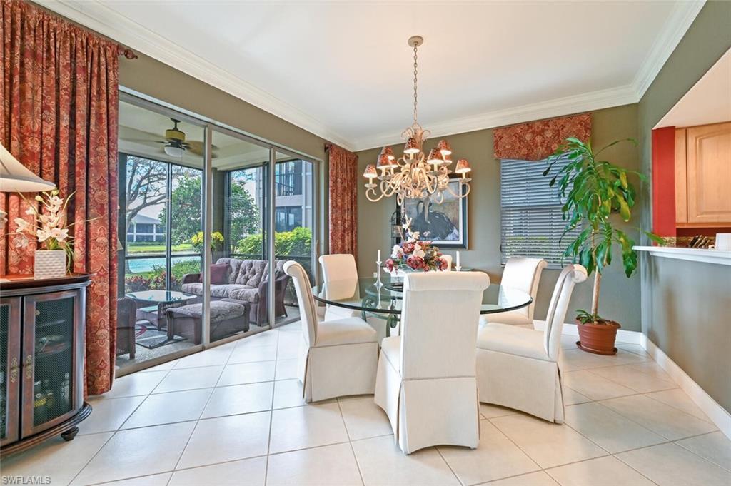 793 Regency Reserve Circle, Unit 4502 Naples, FL 34119 - Photo 8 of 24 a dining room with furniture a chandelier and fireplace