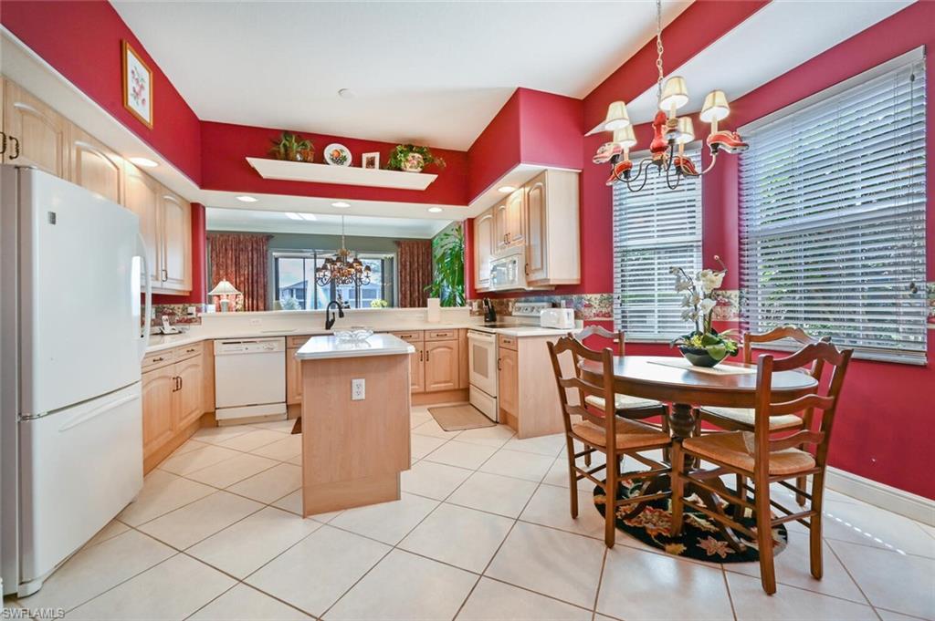 793 Regency Reserve Circle, Unit 4502 Naples, FL 34119 - Photo 9 of 24 a kitchen with stainless steel appliances a dining table chairs and a refrigerator