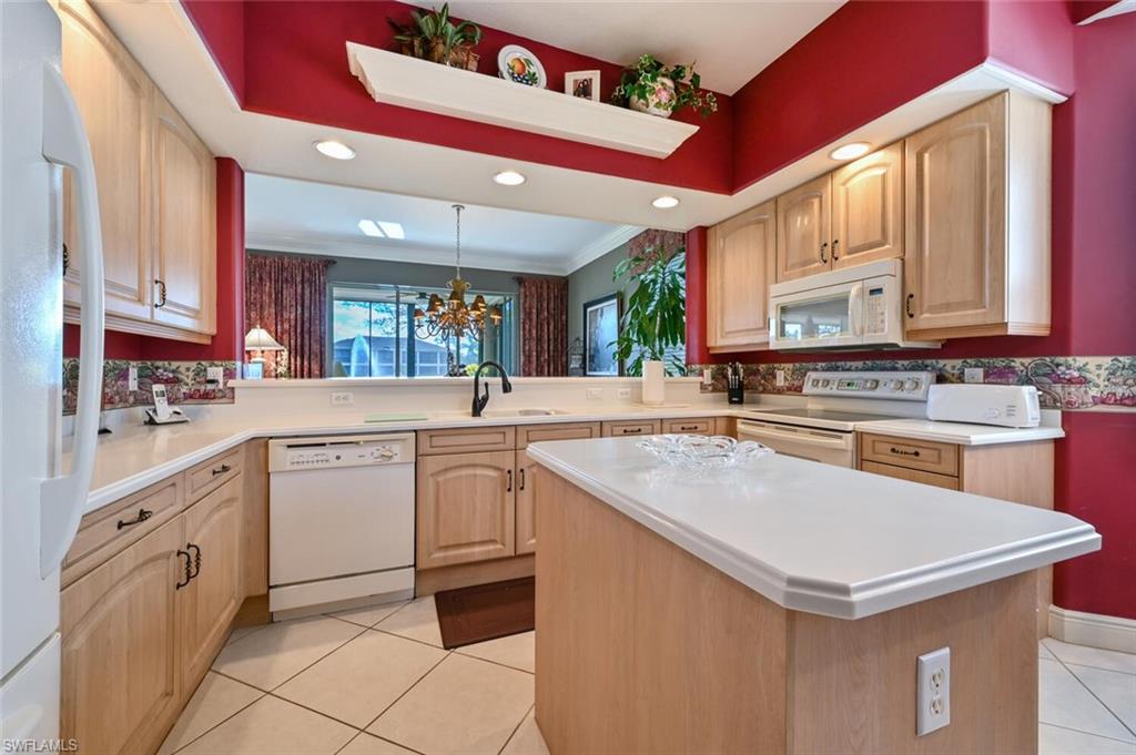 793 Regency Reserve Circle, Unit 4502 Naples, FL 34119 - Photo 10 of 24 a kitchen with granite countertop a sink appliances cabinets and a counter top space