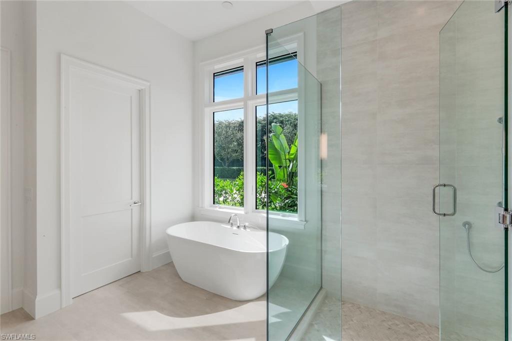 16728 Enclave Circle Naples, FL 34110 - Photo 22 of 49 Bathroom with a stall shower and a soaking tub