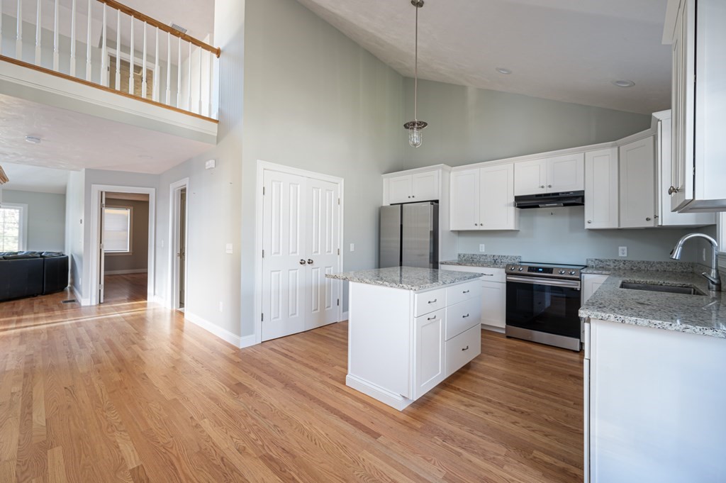5 Turtle Lane, Unit 5 Sterling, MA 01564 - Photo 4 of 30 a kitchen with stainless steel appliances granite countertop a stove top oven a refrigerator a sink and dishwasher with wooden floor