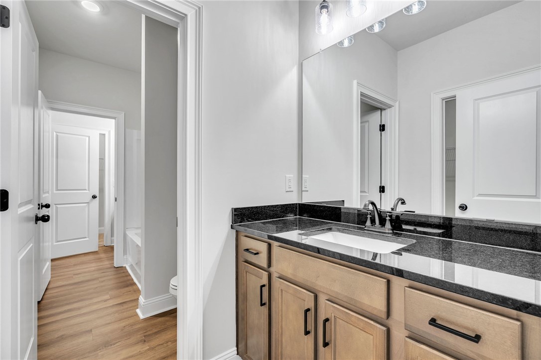 226 Holly Br Road Piedmont, SC 29673 - Photo 28 of 44 Refined bathroom with sleek granite counters and natural wood-tone cabinetry, offering serene privacy.