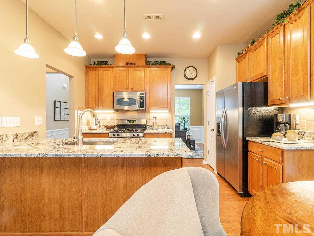 3901 Cathedral Bell Road Raleigh, NC 27614 - Photo 11 of 30 a kitchen with stainless steel appliances granite countertop a sink a stove and a refrigerator