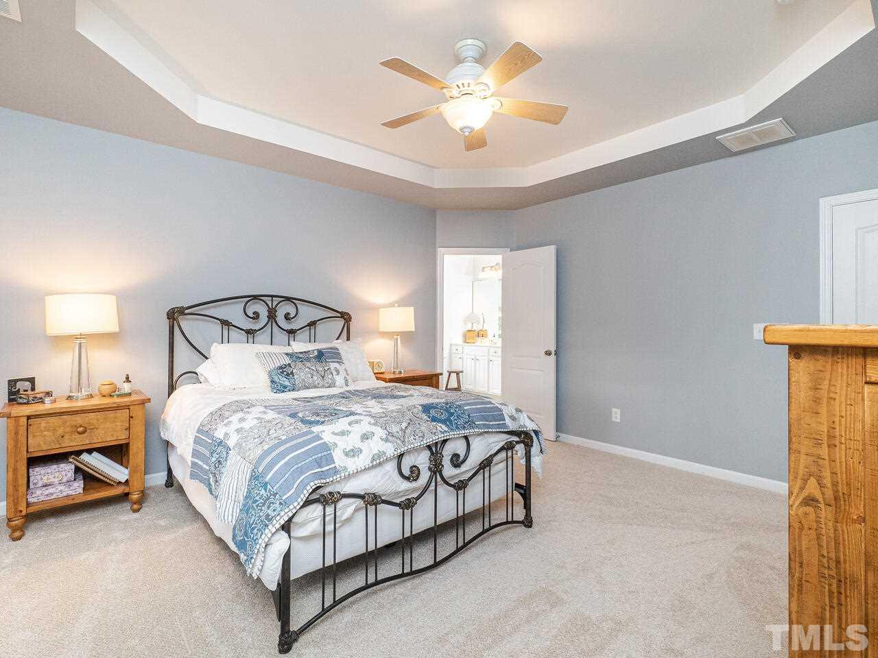 3901 Cathedral Bell Road Raleigh, NC 27614 - Photo 16 of 30 a bedroom with a bed and a chandelier