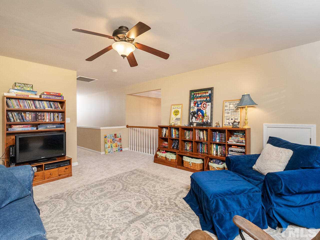 3901 Cathedral Bell Road Raleigh, NC 27614 - Photo 21 of 30 a living room with furniture a flat screen tv and a book shelf