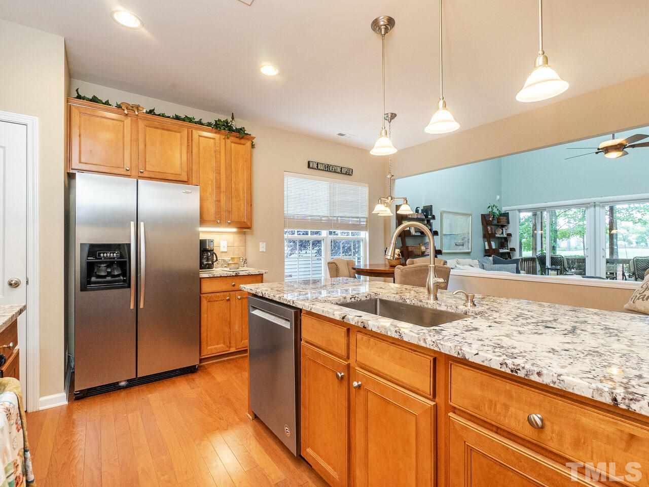 3901 Cathedral Bell Road Raleigh, NC 27614 - Photo 7 of 30 a kitchen with stainless steel appliances granite countertop a refrigerator a sink a stove and a wooden floors