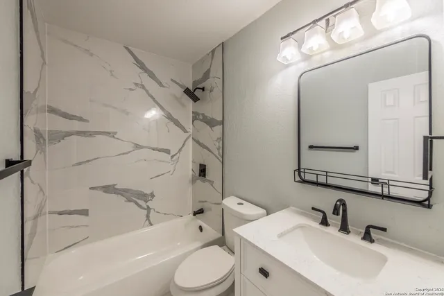 a bathroom with a toilet sink and shower