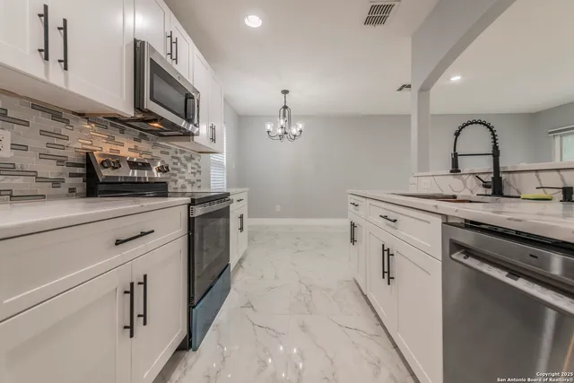 a kitchen with stainless steel appliances granite countertop a sink and a stove