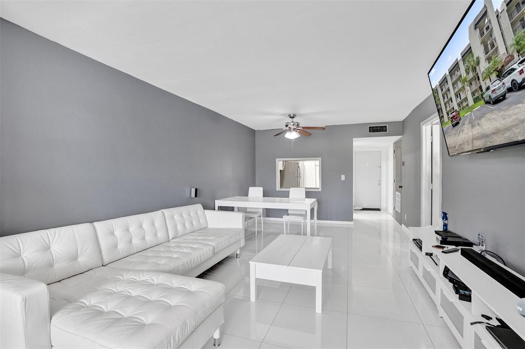 9235 Lagoon Place, Unit 207 Davie, FL 33324 - Photo 11 of 59 a living room with furniture and a chandelier