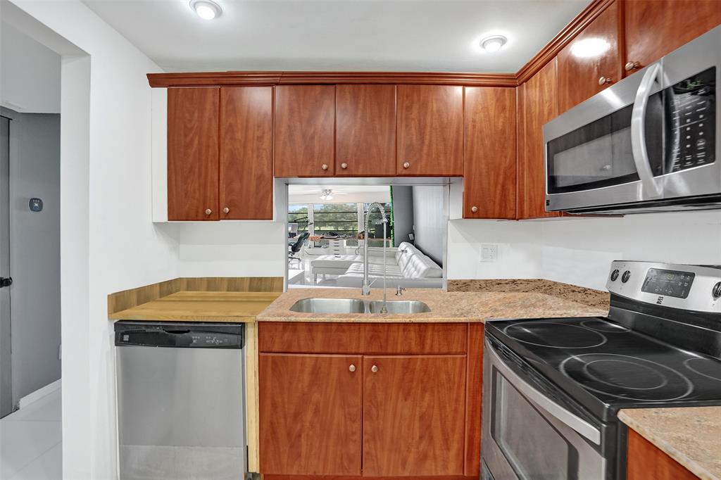 9235 Lagoon Place, Unit 207 Davie, FL 33324 - Photo 15 of 59 a kitchen with stainless steel appliances granite countertop a sink stove and cabinets